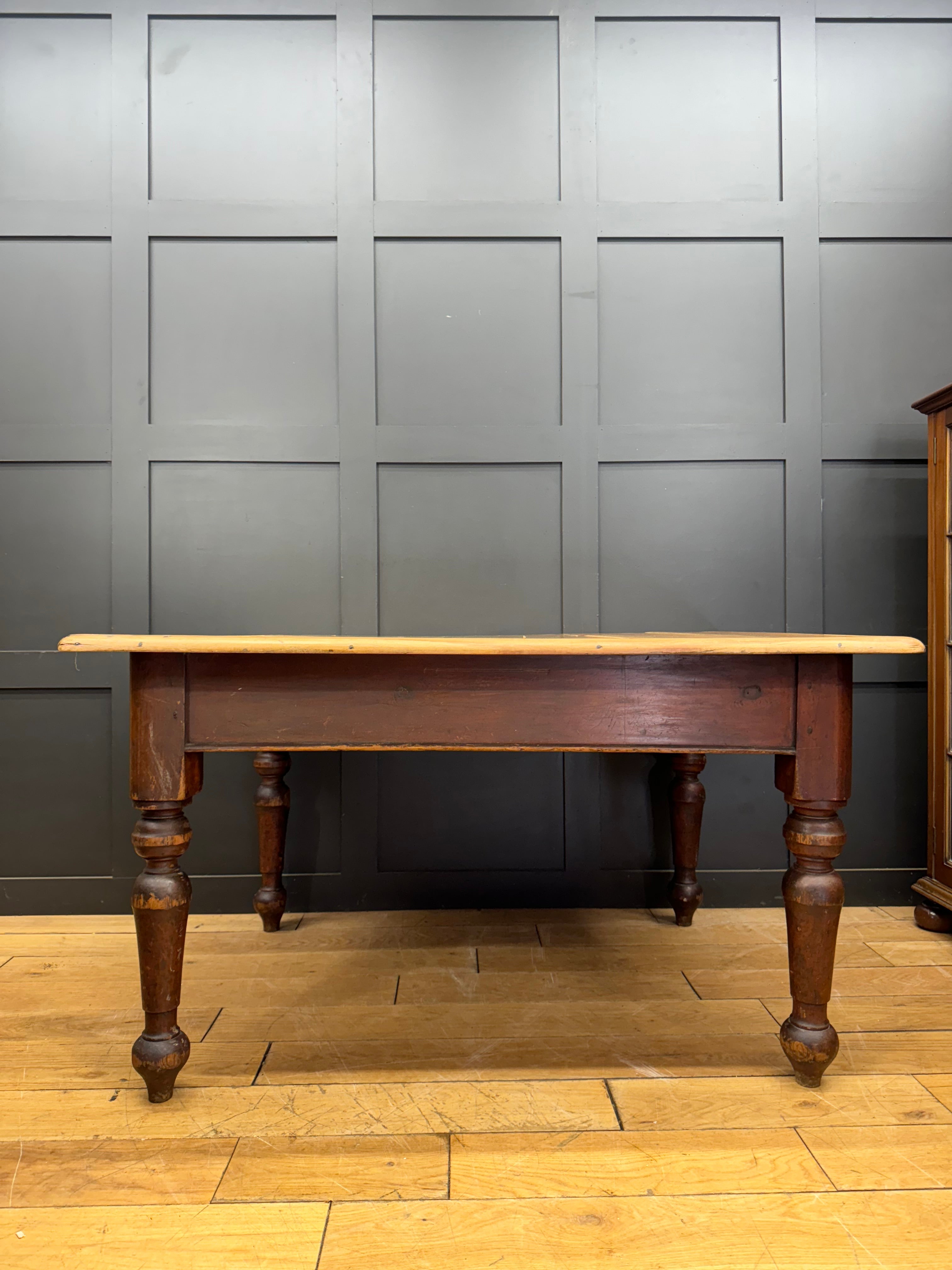 Antique pine kitchen table with dark brown turned legs and a lighter natural wood top perfect for farmhouse style