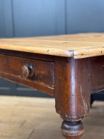 Antique pine kitchen table with worn light wood top and dark stained legs featuring turned feet vintage farmhouse style