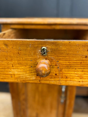 Antique pine pedestal desk drawer in warm amber wood with rounded knob and brass keyhole detail