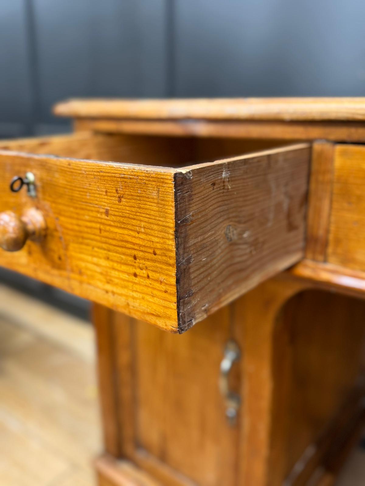 Antique pine pedestal desk dressing table with warm amber pine finish and visible wood grain patterns in pine pedestal desk