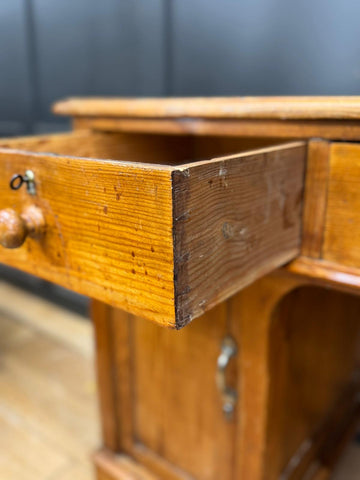 Antique pine pedestal desk dressing table with warm amber pine finish and visible wood grain patterns in pine pedestal desk