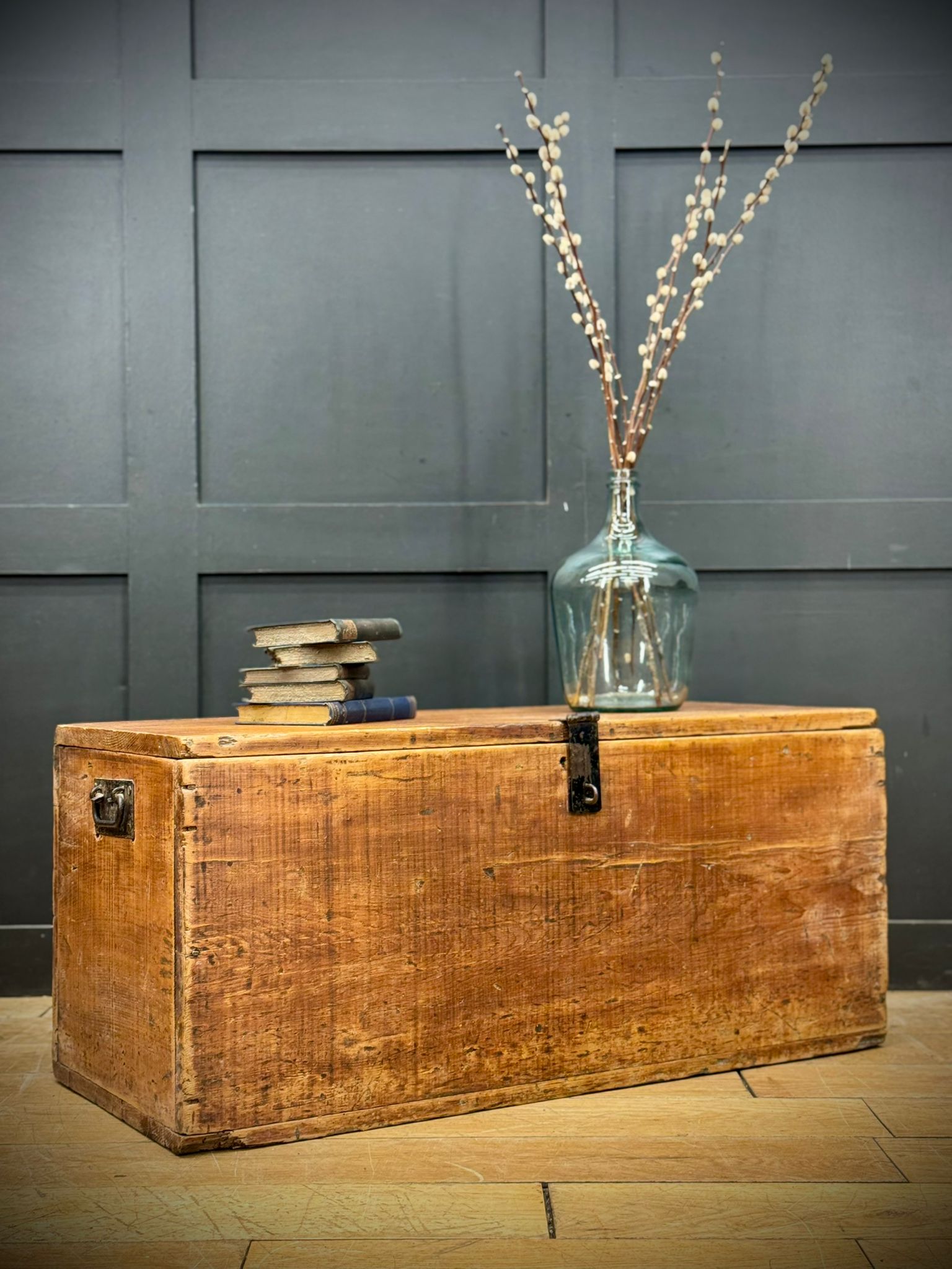 Antique pine storage chest with a warm amber finish and black metal latches perfect as a rustic blanket box or coffee table trunk
