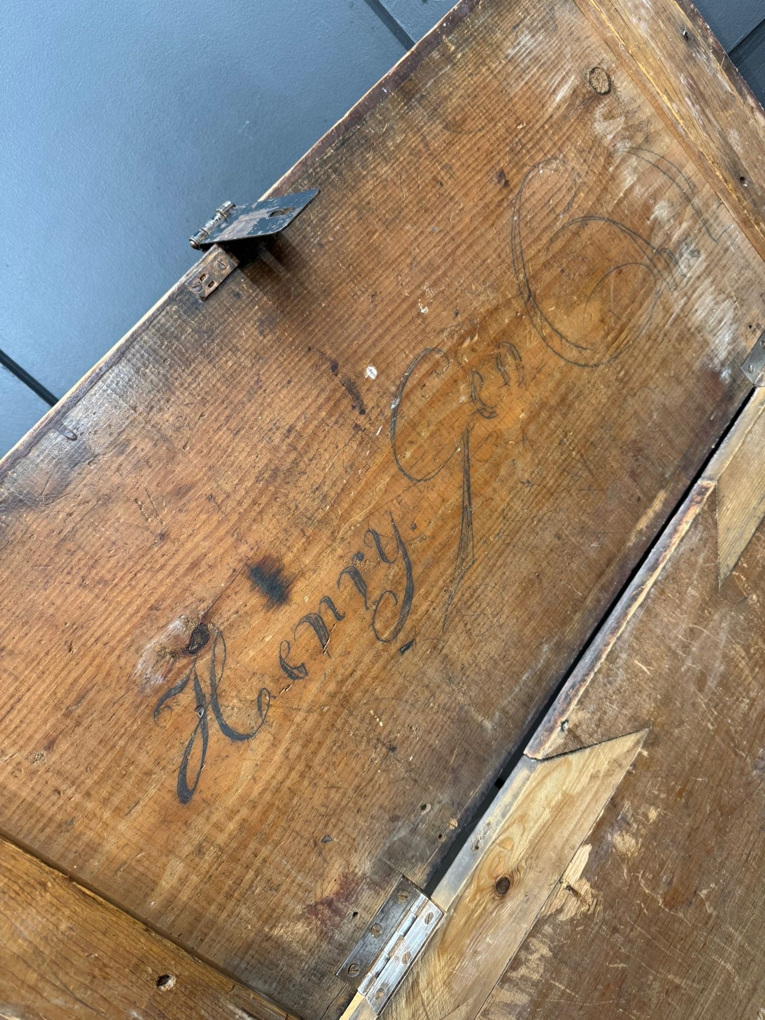Weathered antique pine storage chest with rustic hand carved henry inscription and metal hinges for blankets or table use