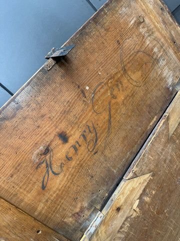 Weathered antique pine storage chest with rustic hand carved henry inscription and metal hinges for blankets or table use