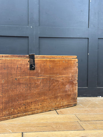 A rustic antique pine storage chest with weathered wood and dark metal latch perfect as blanket box or coffee table trunk