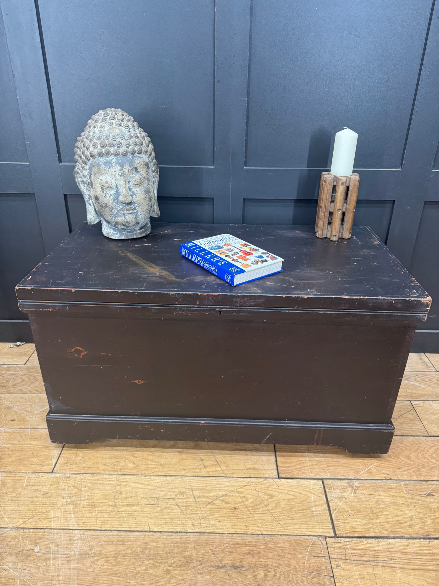 Dark brown wooden antique pine trunk with worn finish used as blanket box or coffee table