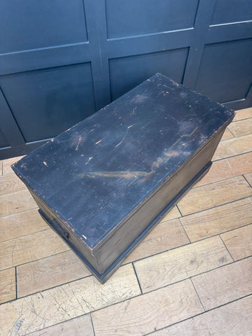 Black painted wooden chest with worn chipped paint vintage antique pine trunk used as blanket box or coffee table