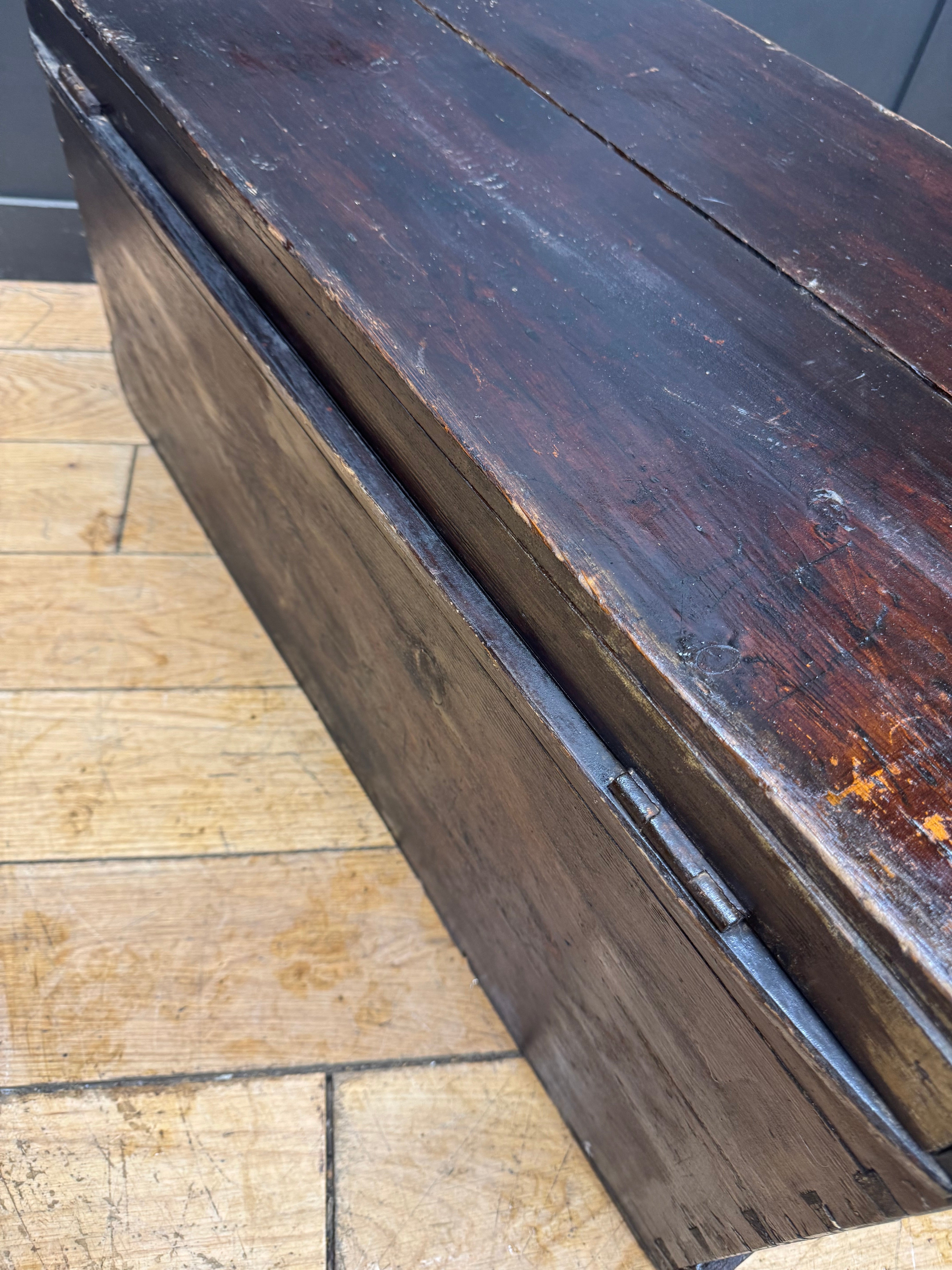 Dark brown antique pine trunk chest with visible wood grain and metal hinge perfect as a coffee table or storage box
