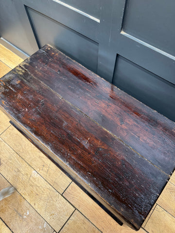 A weathered dark brown pine trunk chest with rustic finish and wood grain used as coffee table and storage box