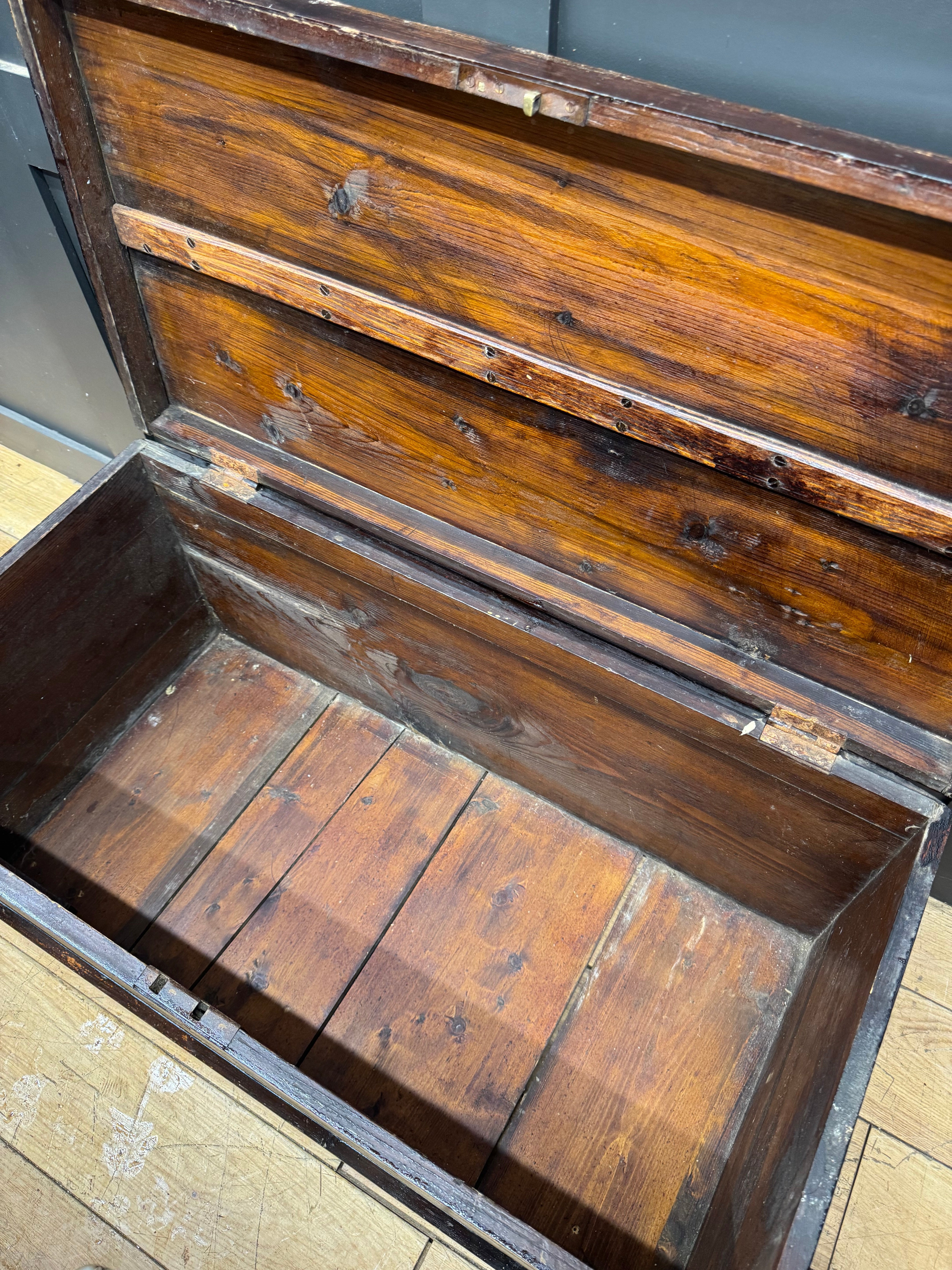 Antique pine trunk chest coffee table with warm brown finish and visible wood grain patterns for rustic storage