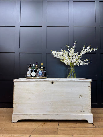 White distressed wooden pine trunk with metal corner hardware and small lock for storage or sideboard use