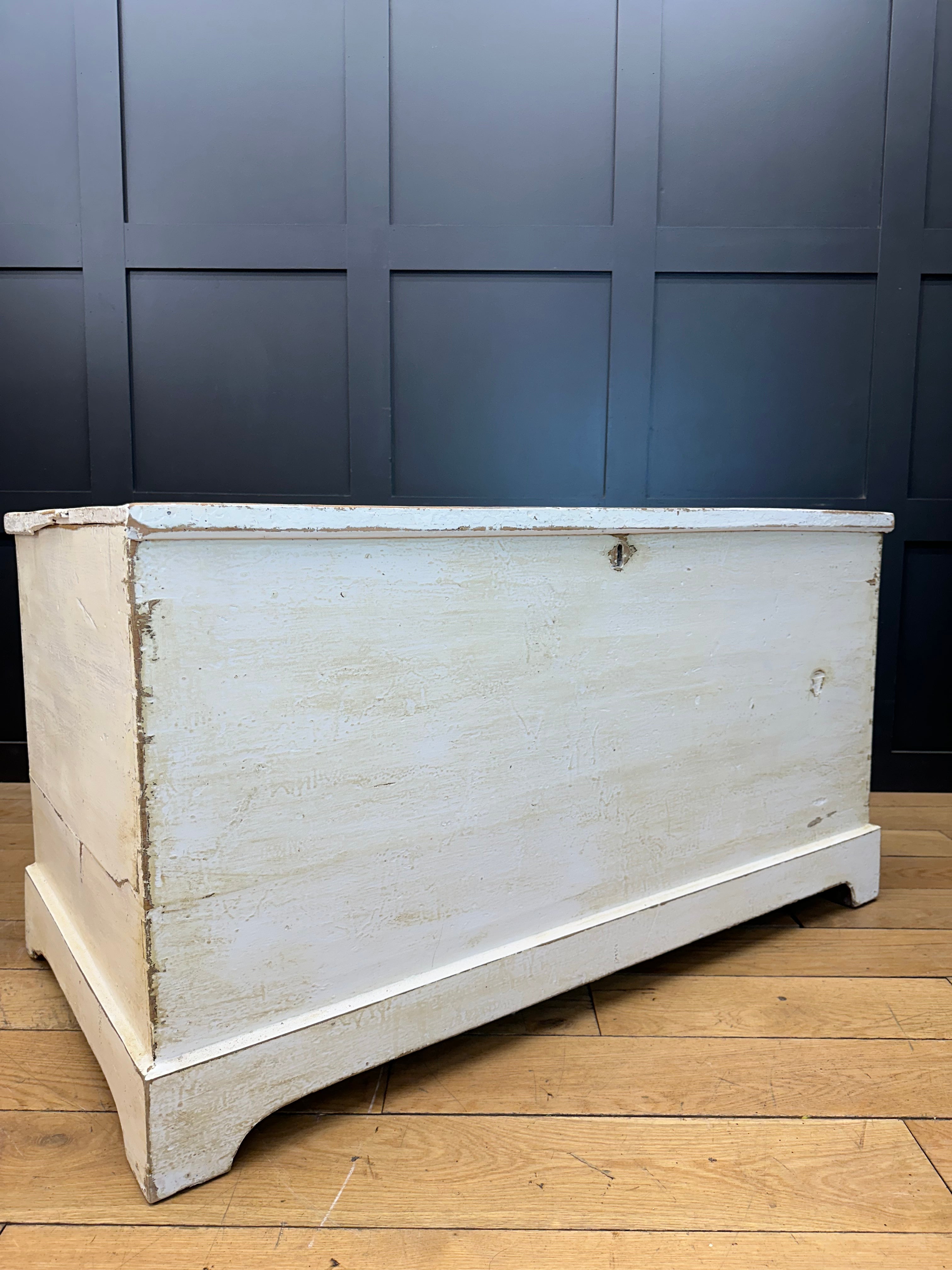 White distressed pine trunk with metal latch and worn edges perfect as a blanket box or sideboard