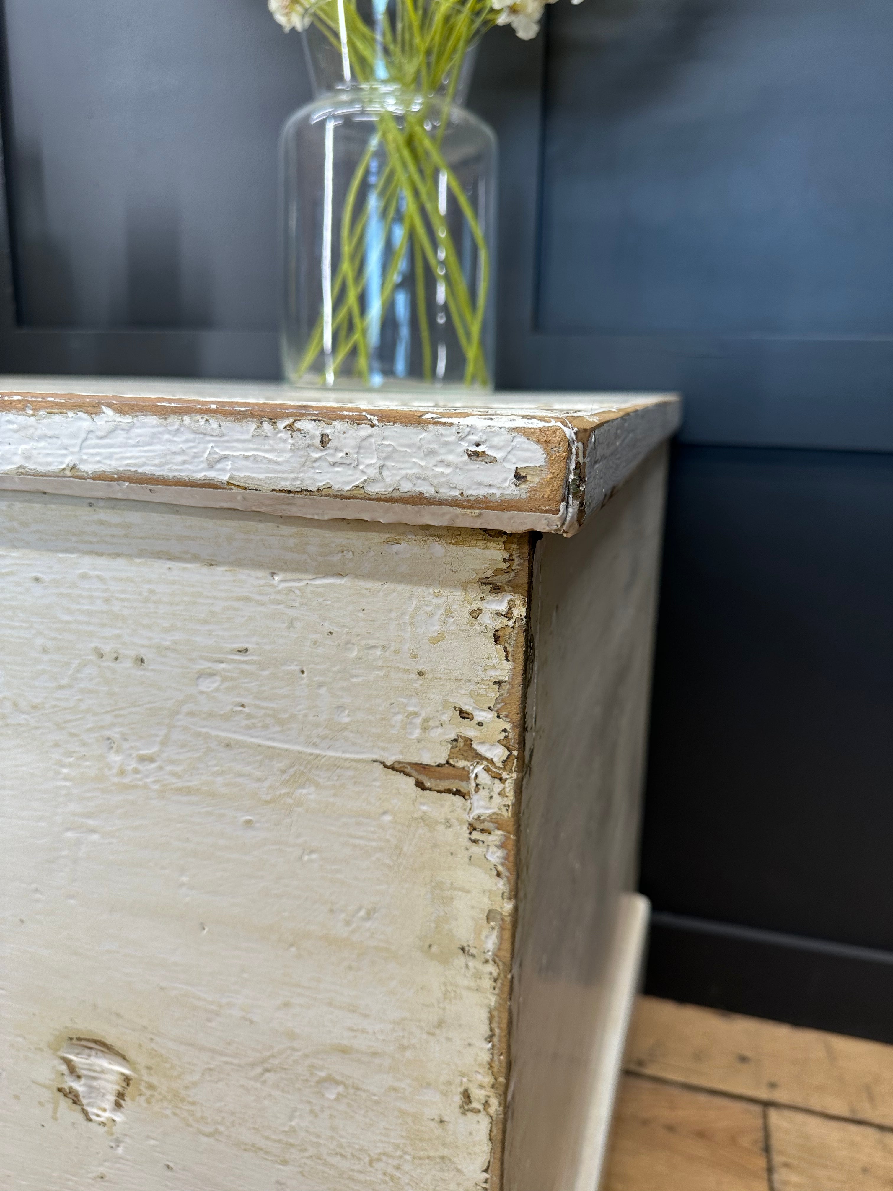 Antique white painted pine trunk with chipped paint and visible wood grain perfect as a blanket box or sideboard