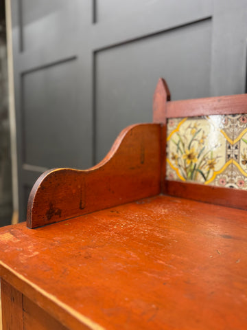 Rustic late victorian pine washstand with wooden knobs and ornate tiled panel featuring yellow daffodils
