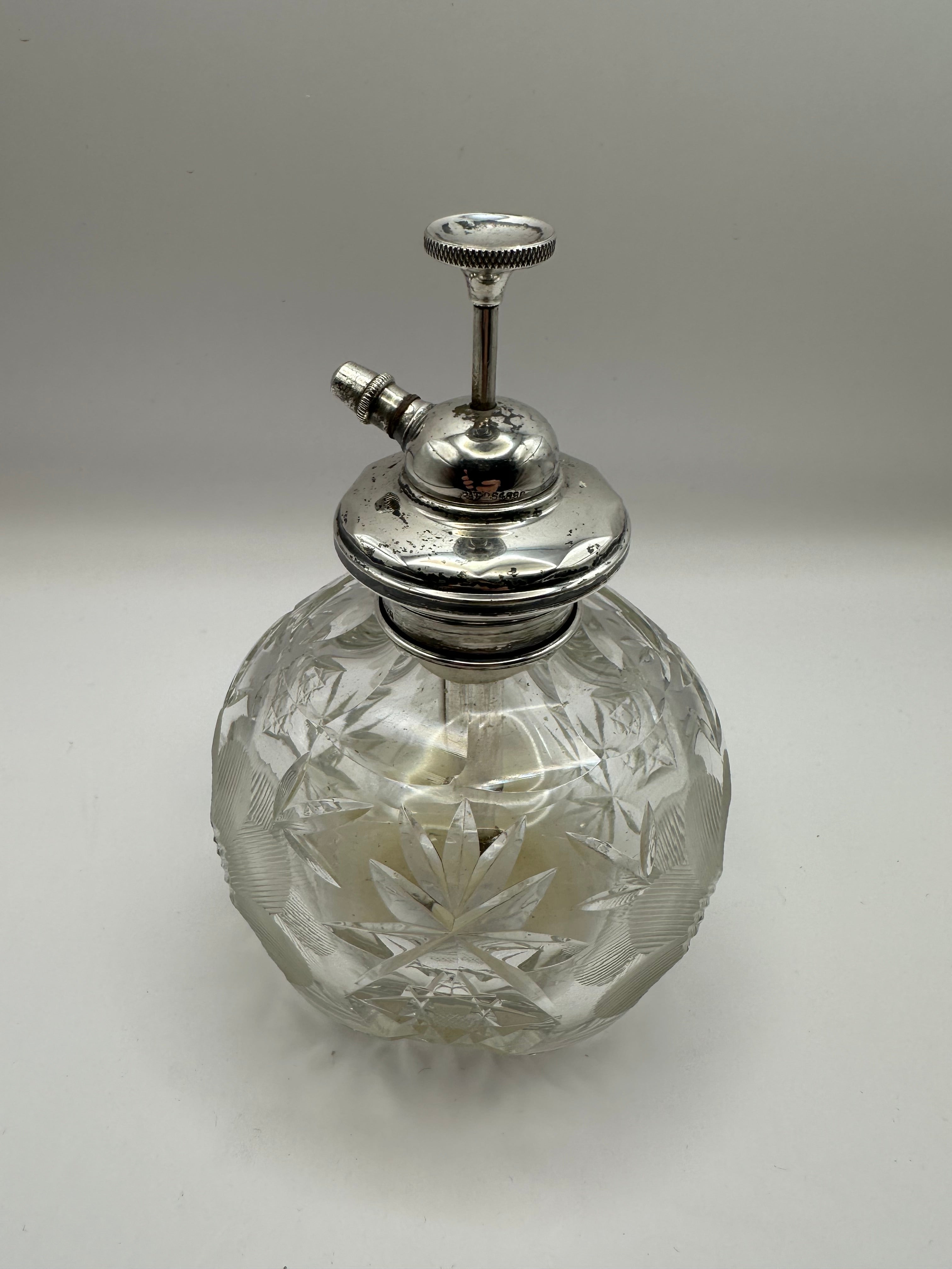 Clear crystal cut glass perfume bottle with starburst etching and polished silver metal spray nozzle for dressing table use