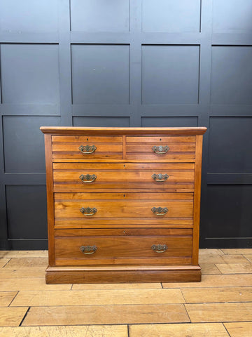 A warm-toned solid walnut antique chest with six drawers and brass handles perfect for bedroom storage