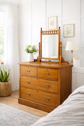 Antique walnut chest of drawers with warm-toned wooden drawer fronts and matching mirror by maple & co edwardian style