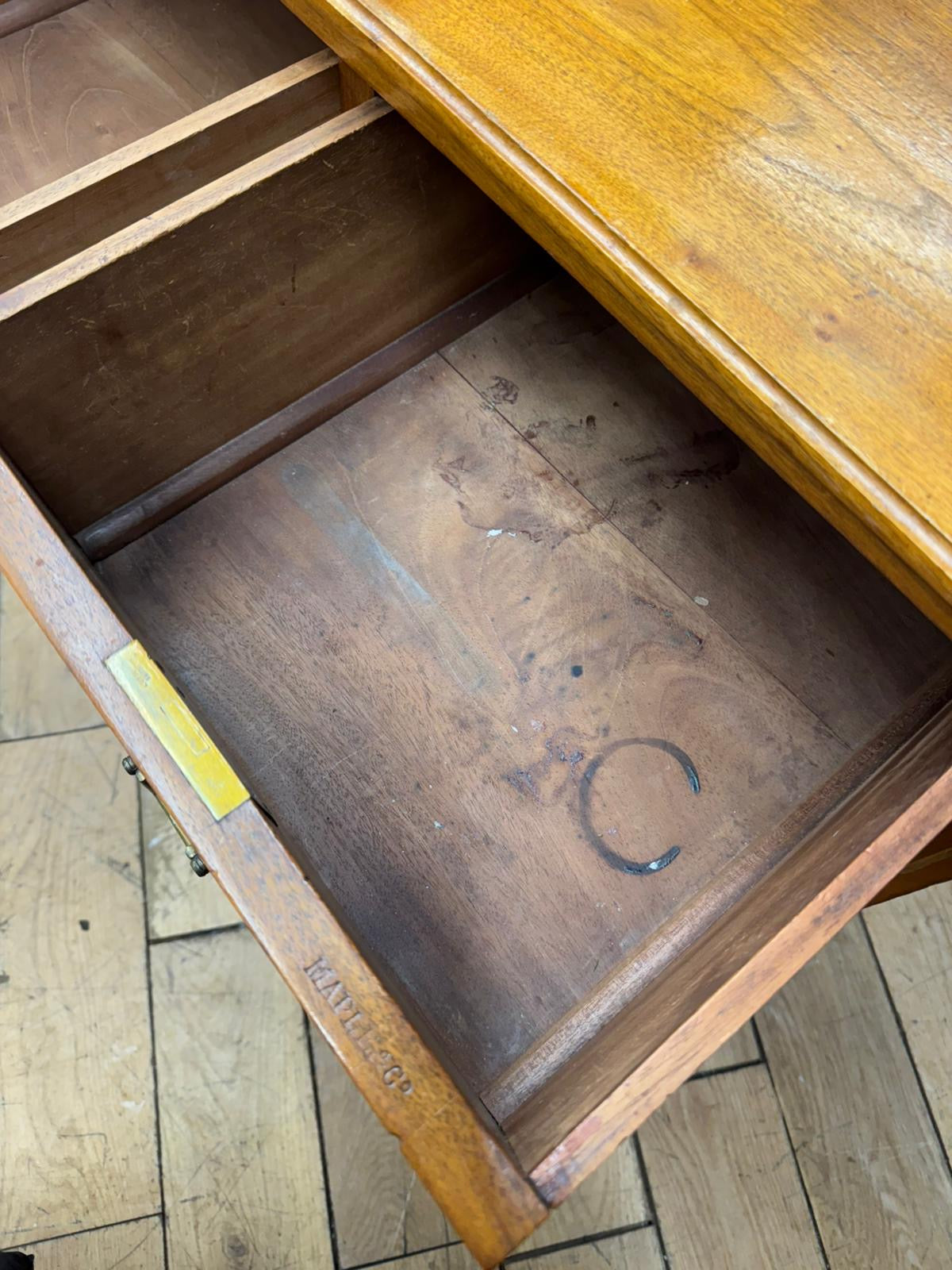 Vintage wooden drawer fronts with polished walnut finish and visible grain on antique chest by maple and co