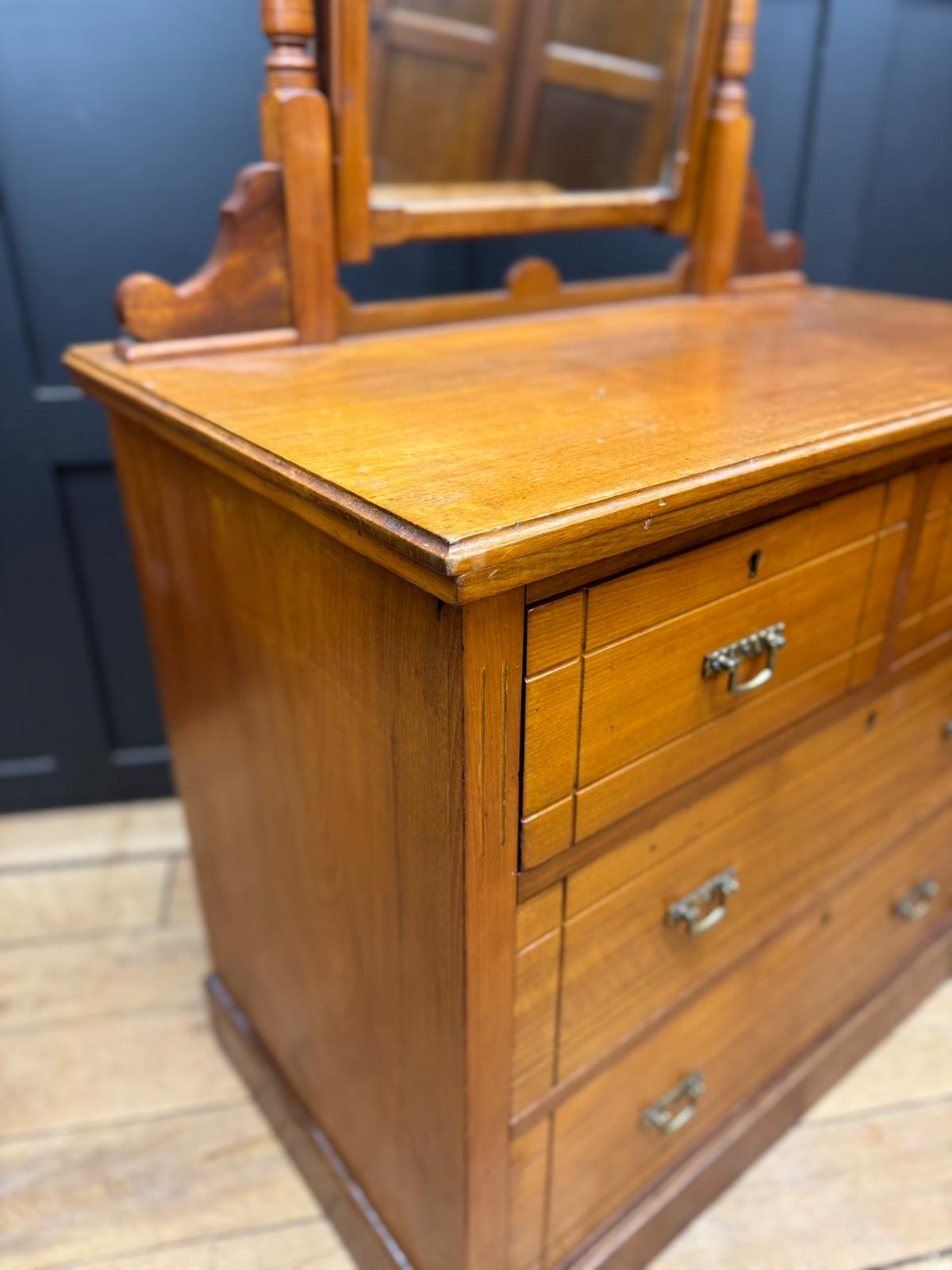 Antique walnut chest of drawers by maple & co with polished oak drawer fronts and ornate carved wood frame mirror above