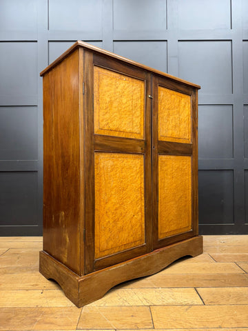 Antique walnut linen cabinet with two doors featuring golden brown burled wood panels in dark brown frame