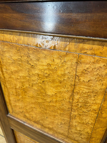 Antique walnut linen cabinet featuring a rich golden-brown burl wood panel with dark wooden trim and swirling grain patterns
