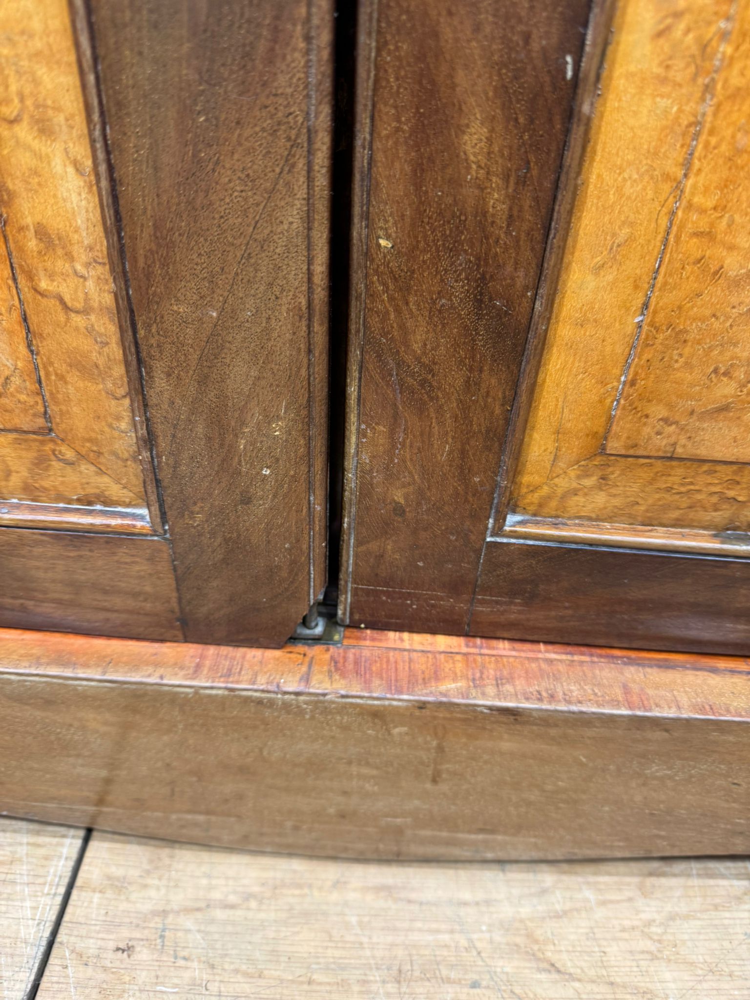 Dark brown wooden cabinet doors with subtle grain and raised panels on antique walnut linen cabinet for storage