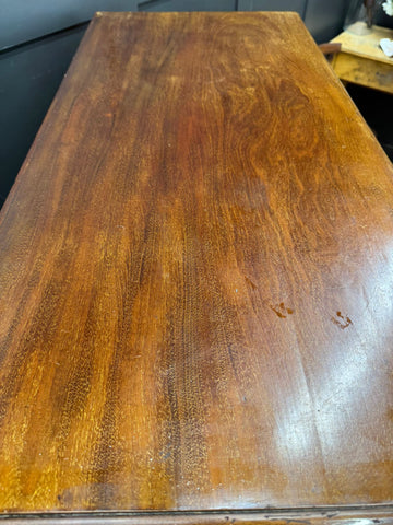 Polished mahogany wooden table top with rich warm brown finish and grain on antique walnut linen cabinet