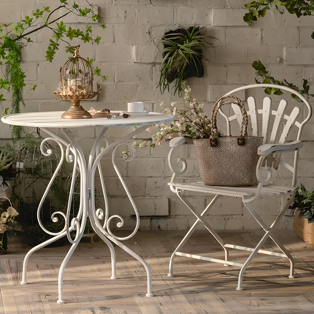 White wrought iron patio table with ornate scrollwork legs and round top from antonia outdoor garden dining set