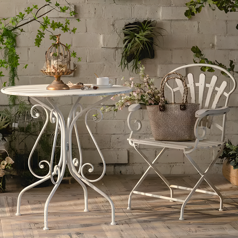 White wrought iron patio table with ornate scrollwork legs and round top from antonia outdoor garden dining set