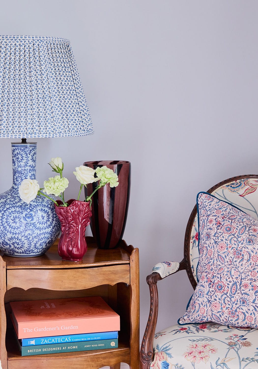 Blue and white patterned ceramic lamp with matching pleated shade next to antonia twilight floral cushion cover