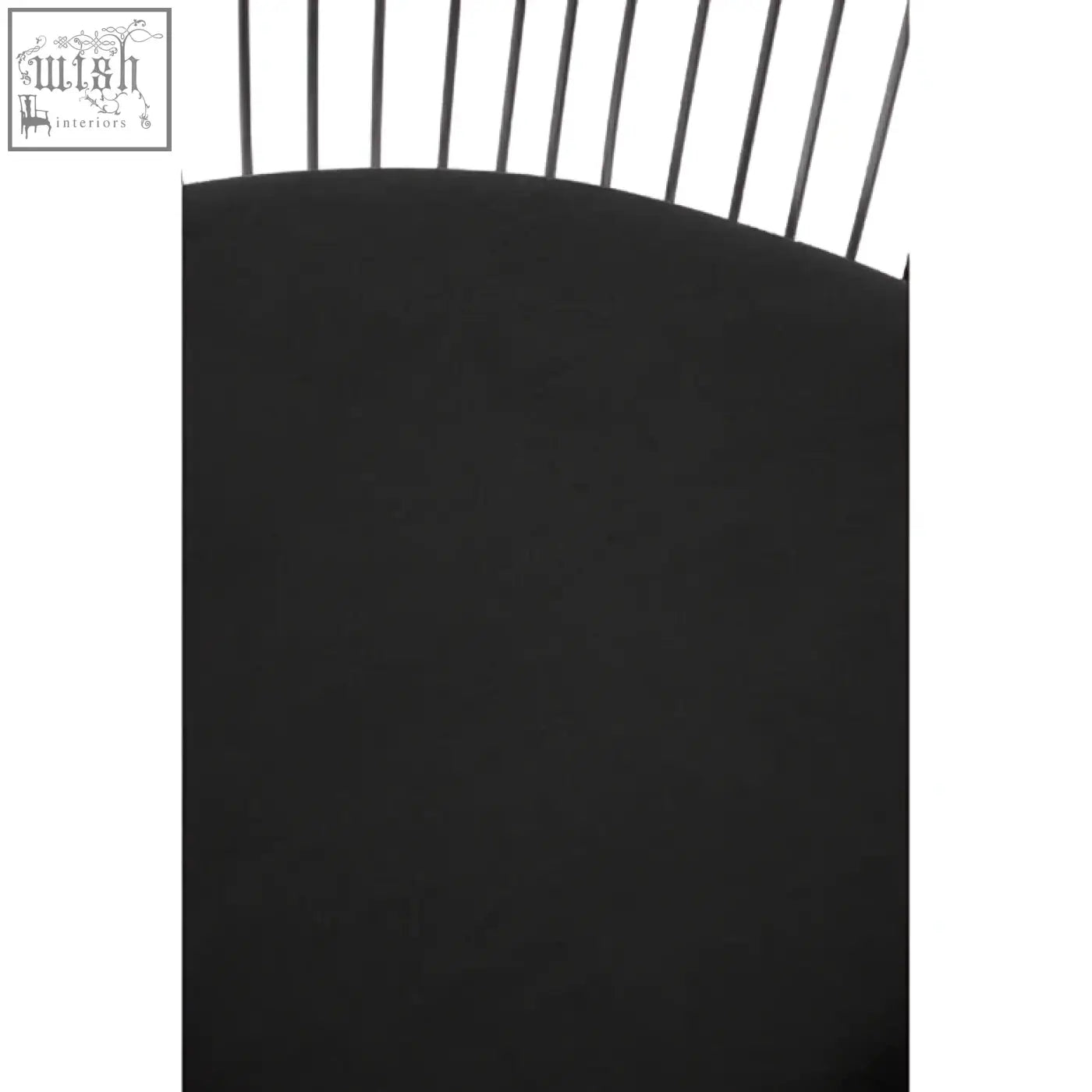 Black curved metal gate with vertical bars shown behind the anzio black velvet and brushed silver chair