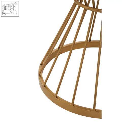 Gold-toned metal wireframe base of anzio hourglass dining table with white marble top and geometric conical design