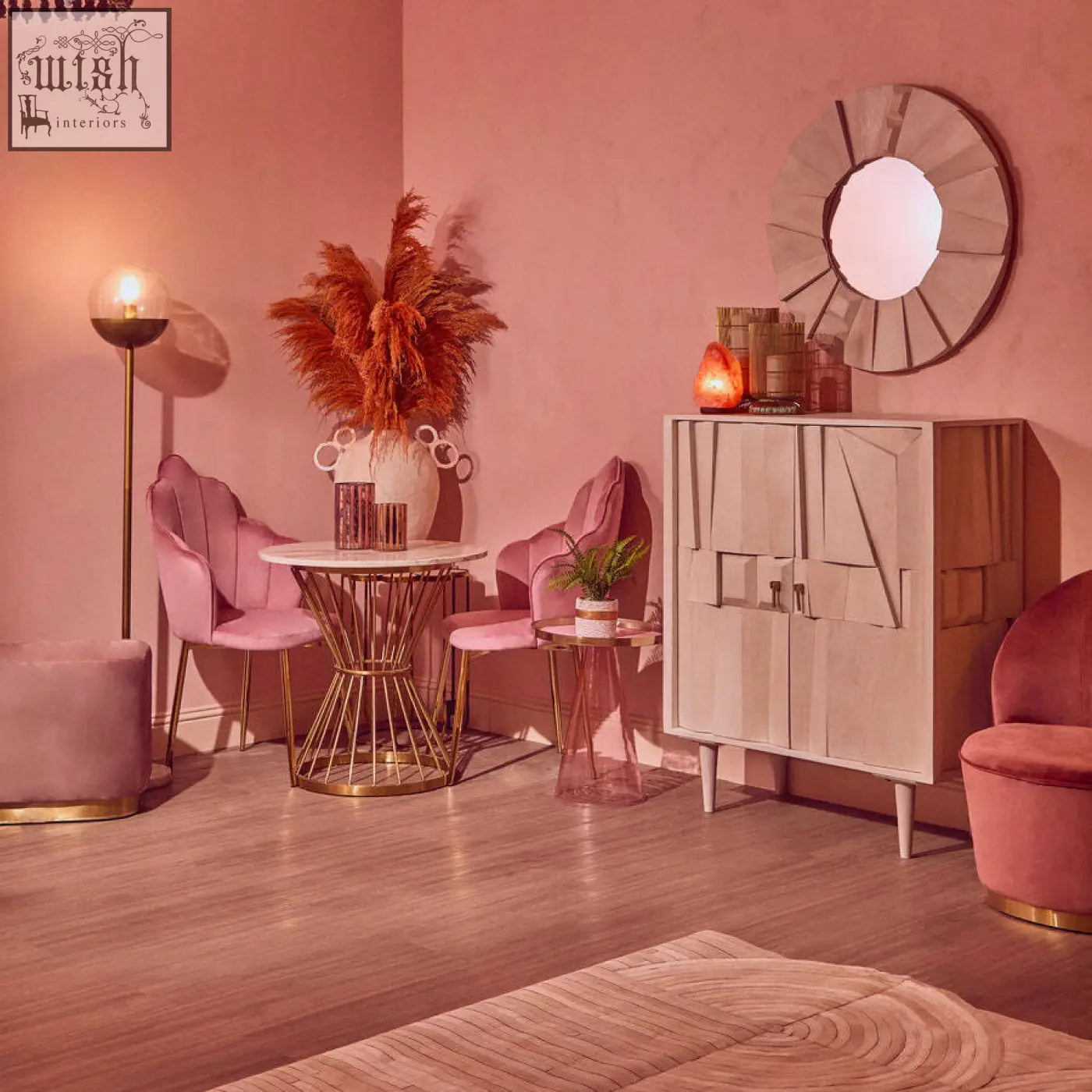 A modern geometric cabinet with light beige finish and angular paneling next to an anzio hourglass dining table with white marble top and gold base