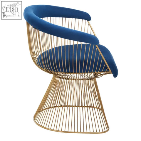 A modern anzio navy blue velvet chair with plush seat and brushed gold wireframe and curved backrest