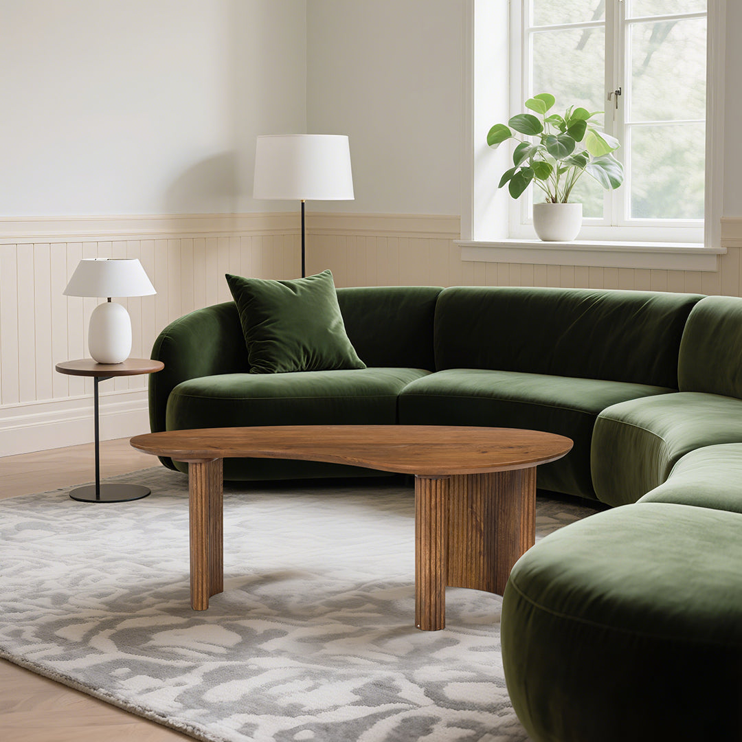 Dark green velvet sectional sofa with matching cushion paired with aragon curved wood coffee table