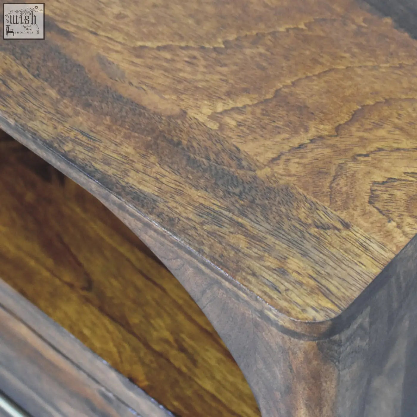 Arc bedside table with rich warm-toned wooden surface natural grain and smooth finish