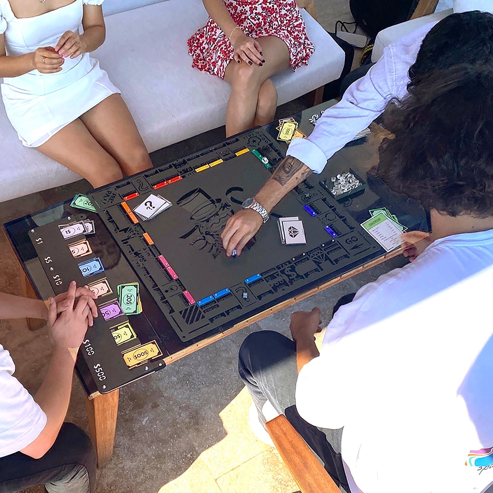 Black archopoly wall game board with colorful community chest cards and dice on a flat surface for all age ranges