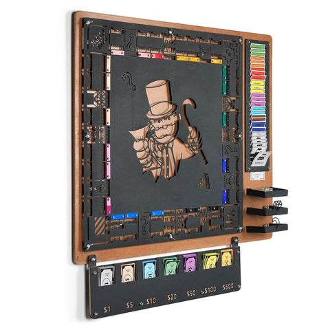 Black metal monopoly game board with laser-cut mr illustration and community chest cards on flat surface for all age range