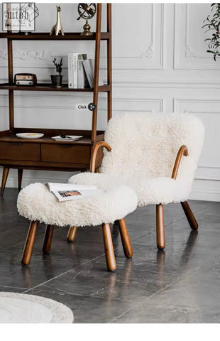 Cream-colored arctander clam armchair made of long hair sheepskin with curved wooden legs and matching ottoman