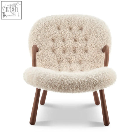 Cream-colored arctander clam armchair with tufted back and wooden legs made from long hair sheepskin