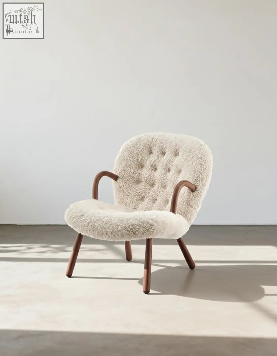 Cream-colored arctander clam armchair with long hair sheepskin tufted back and curved wooden legs