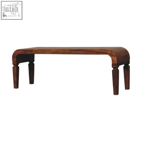 A sleek dark brown arcus coffee table made of oak solid mango wood with curved ends and turned legs for living room