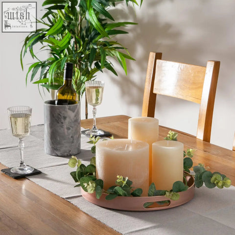 Rosy pink argon tableware round serving tray 33cm holding three cream pillar candles with eucalyptus leaves