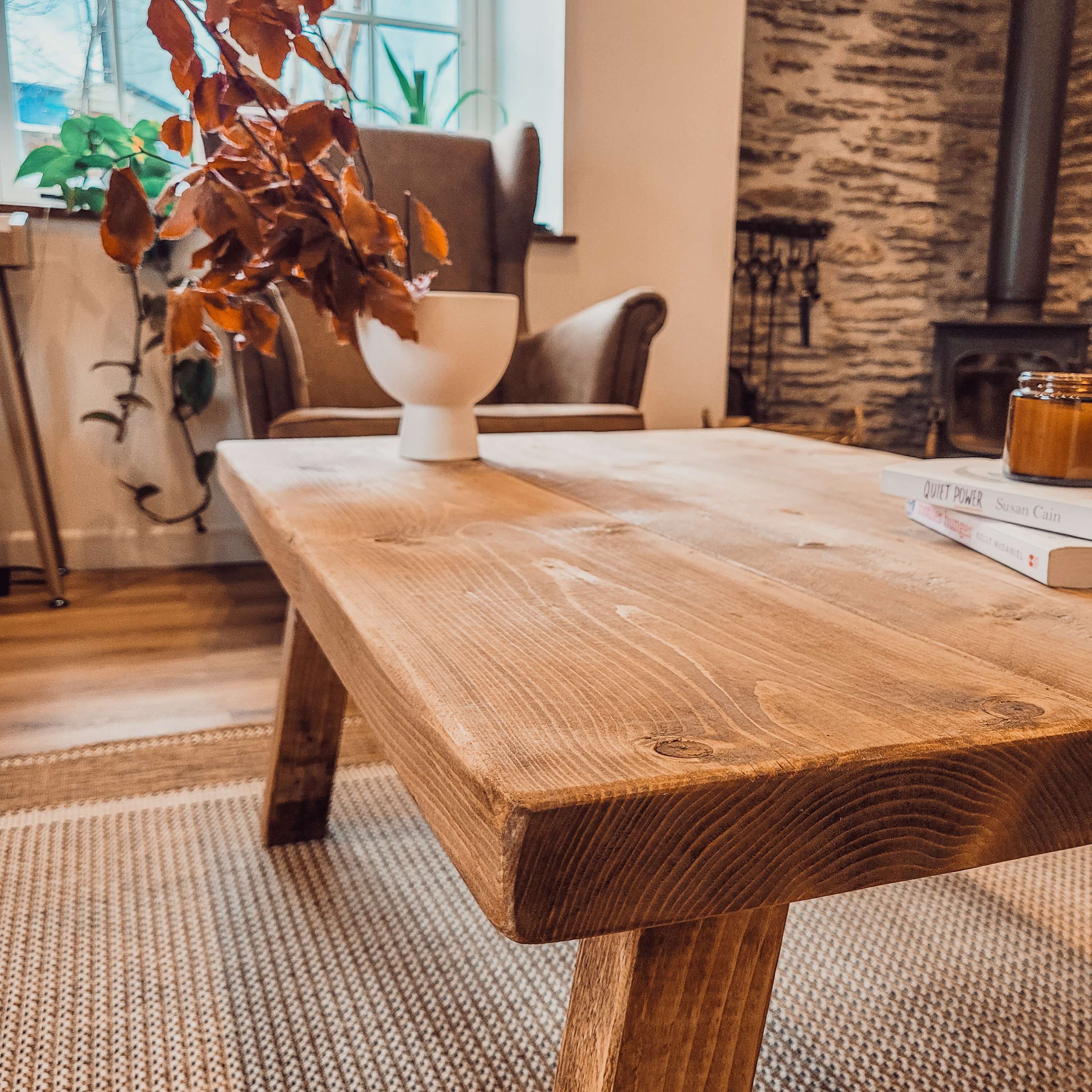 Aria rustic coffee table with a warm natural finish and visible wood grain on a rustic wooden surface