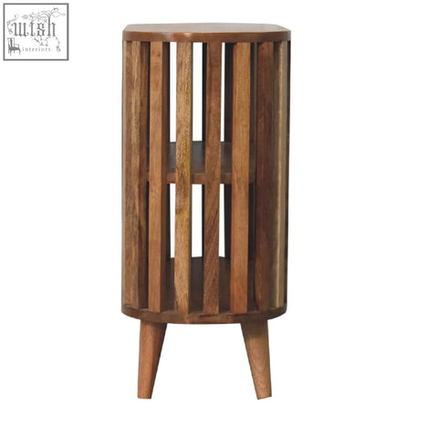 A cylindrical wooden ariella chest side table with vertical slats tapered legs in oak-ish mango wood finish