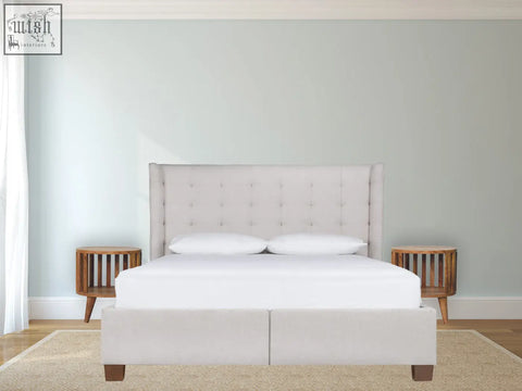 Beige upholstered bed with tufted headboard and footboard shown alongside ariella single shelf bedside table