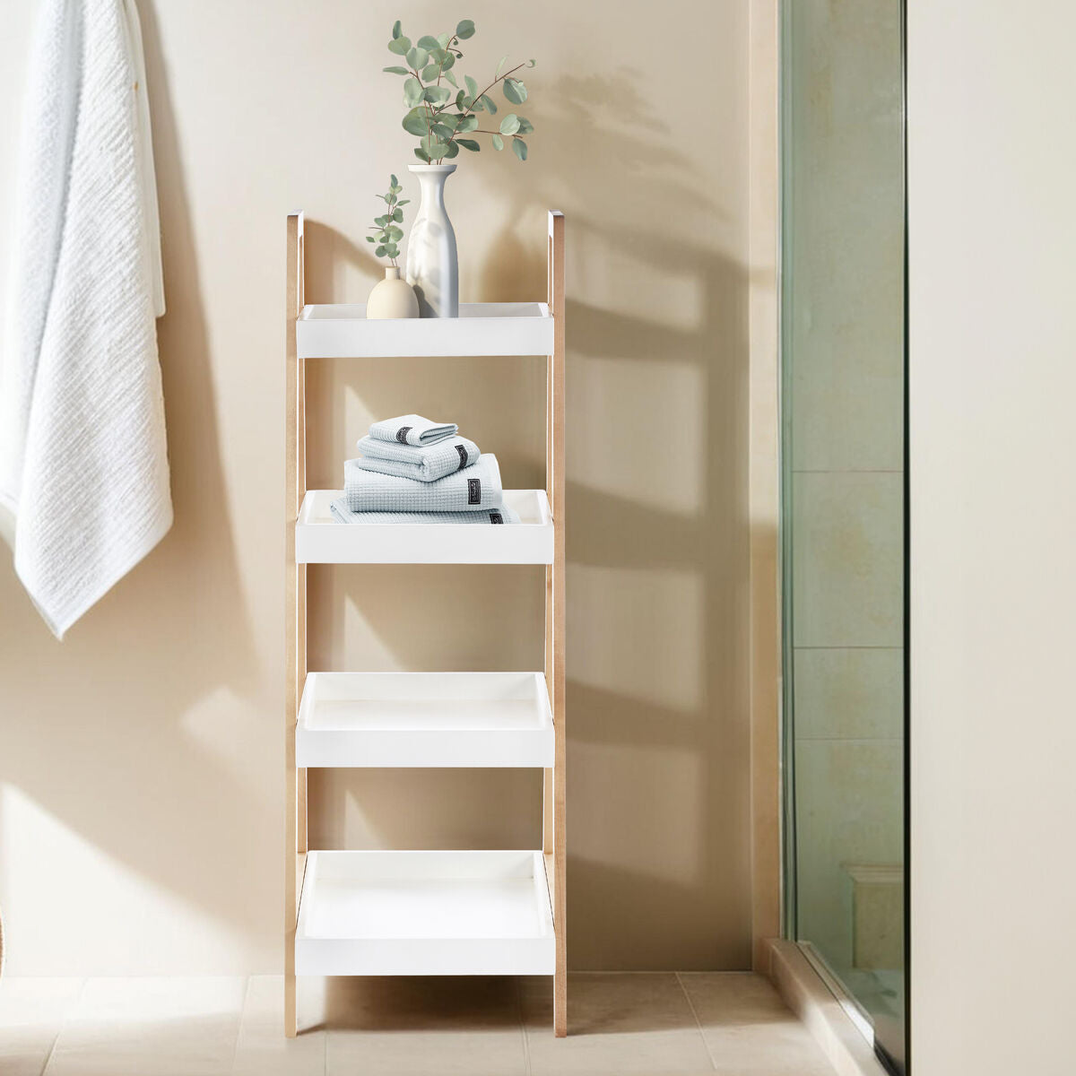 Arla four tier birch wood bathroom shelf unit in white and light wood with folded towels and eucalyptus vase on tiers