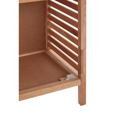 Light brown walnut wood bathroom shelf unit with vertical louvered panels and metal hinge at the base