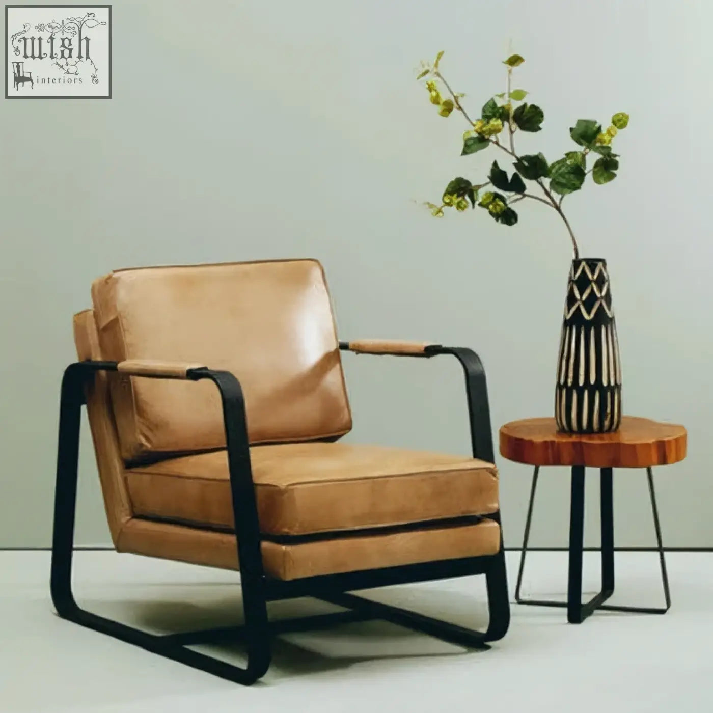 Tan leather armchair with black metal frame shown next to small engraved wooden vase for stylish home decor