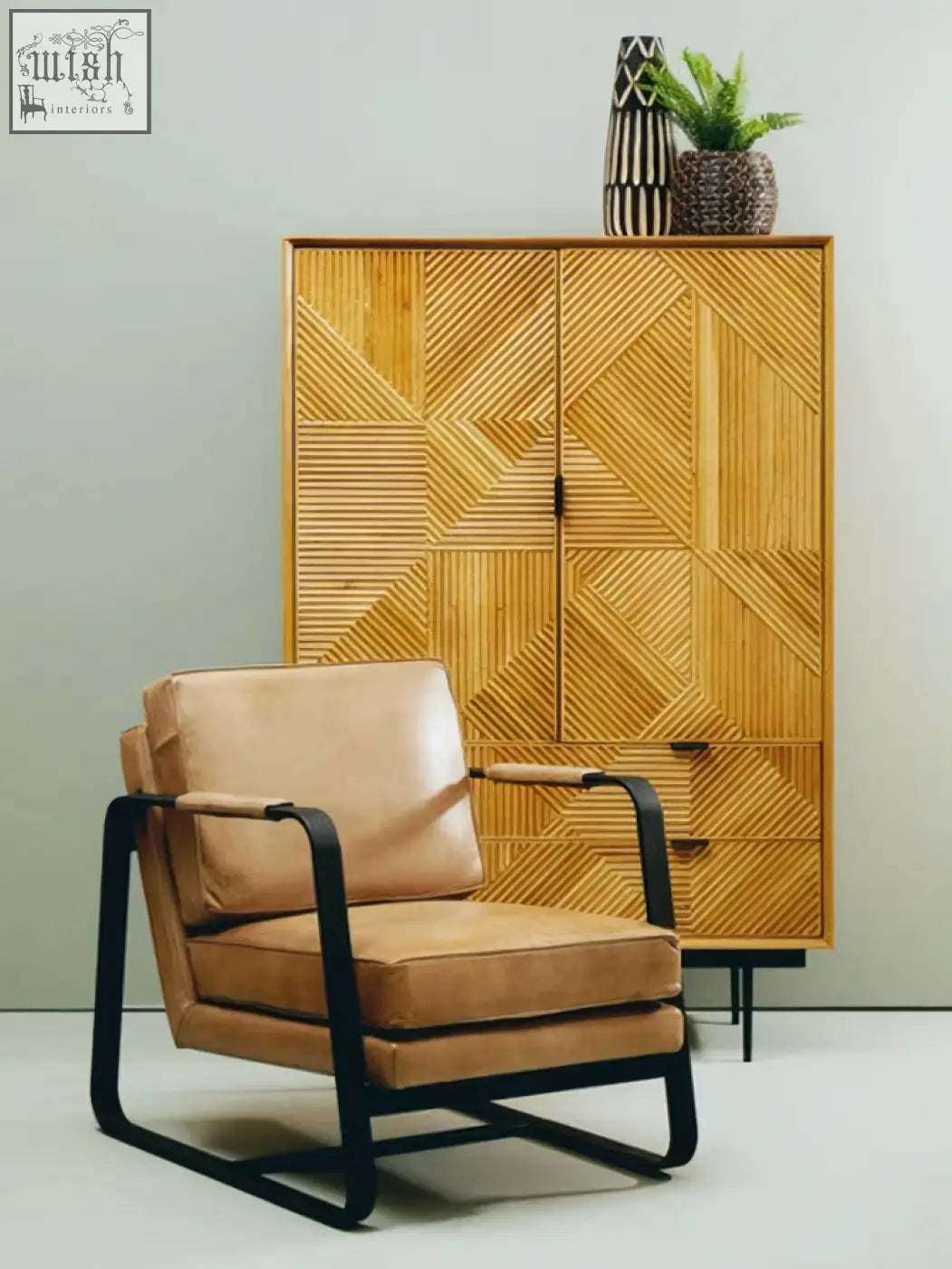 Tan leather armchair with black metal frame paired with a small engraved wooden vase for stylish decor